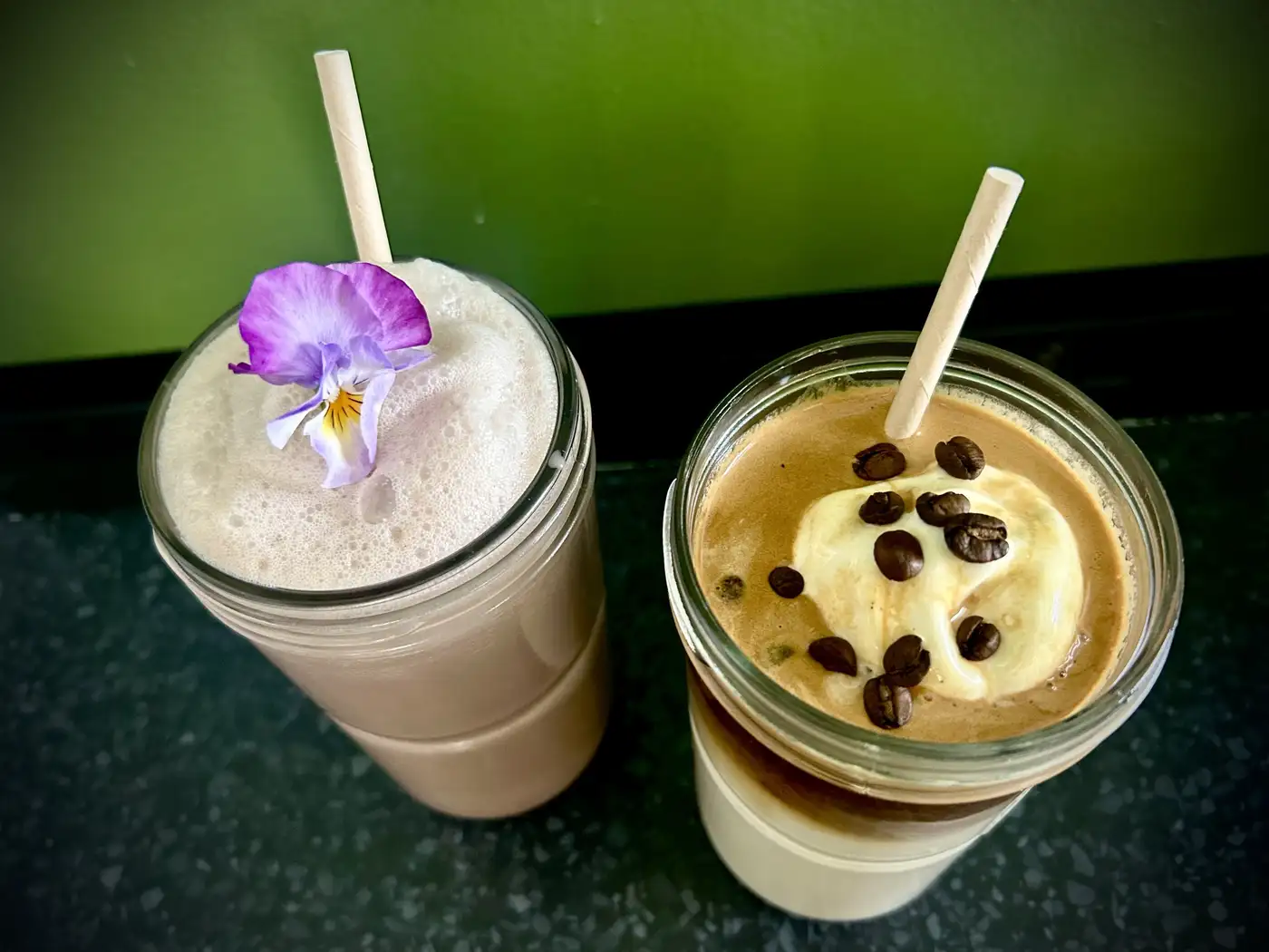 Iced coffee and smoothie in mason jars with edible purple flower